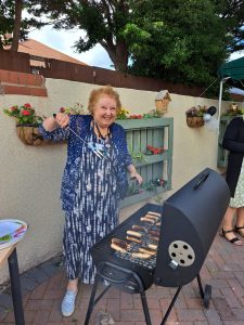 Learning & Education Officer Jan cooking sausages at the barbeque.