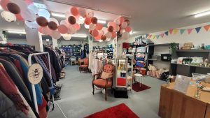 A busy shop floor with rails of clothing, footwear and soft furnishings all visible.